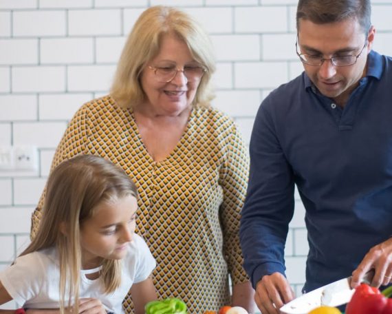 A family happily preparing vegetables together in a modern kitchen.