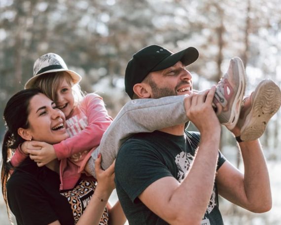 Happy family having fun in a forest, capturing joyful bonding moments.